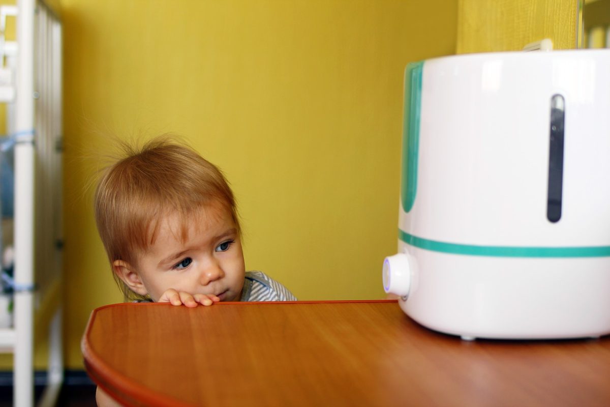 petite-fille-qui-regarde-un-humidificateur-dans-la-chambre à coucher